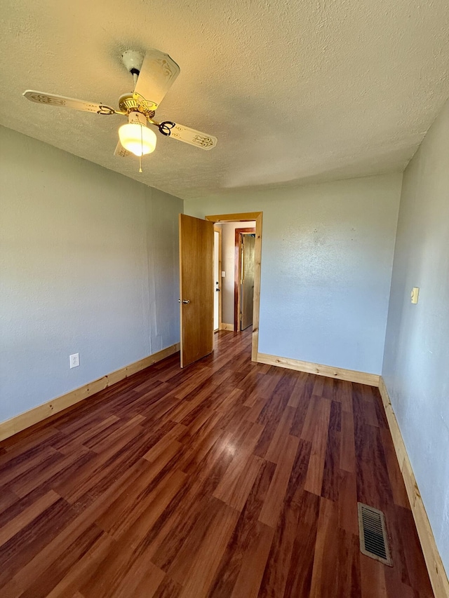 unfurnished room with visible vents, baseboards, wood finished floors, a textured ceiling, and a ceiling fan