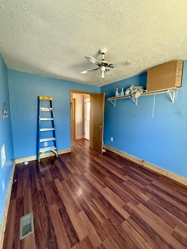 unfurnished bedroom featuring a textured ceiling, wood finished floors, visible vents, and baseboards