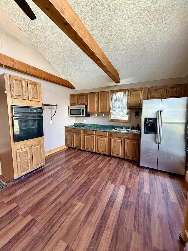 kitchen with brown cabinetry, appliances with stainless steel finishes, lofted ceiling with beams, and dark wood-style flooring