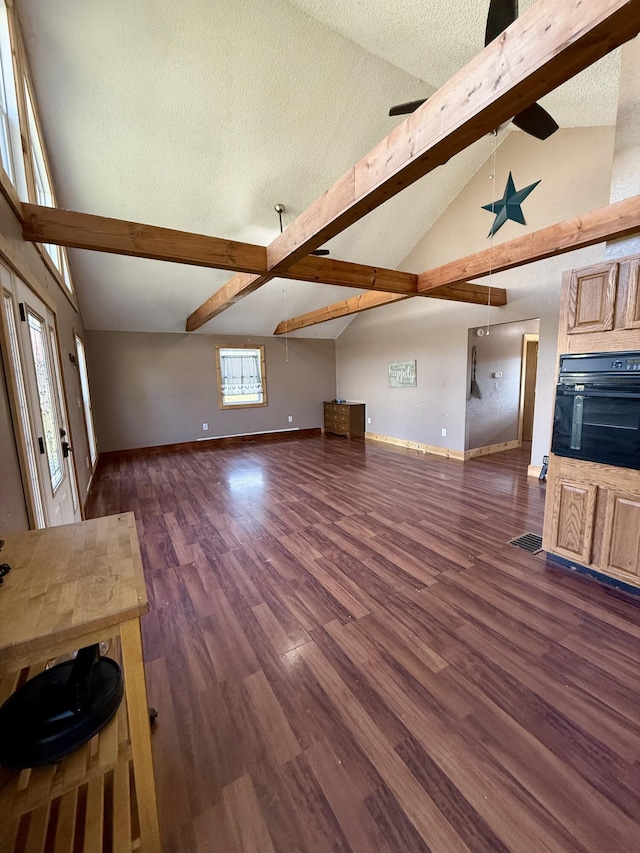 unfurnished living room featuring baseboards, ceiling fan, beamed ceiling, a fireplace, and wood finished floors