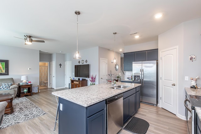 kitchen featuring visible vents, open floor plan, light wood-style flooring, appliances with stainless steel finishes, and a sink