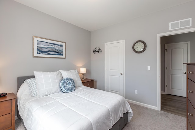 carpeted bedroom with visible vents and baseboards