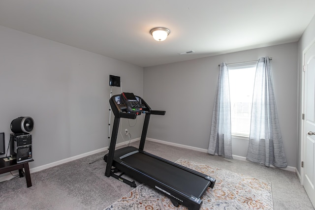 exercise area featuring visible vents, baseboards, and carpet