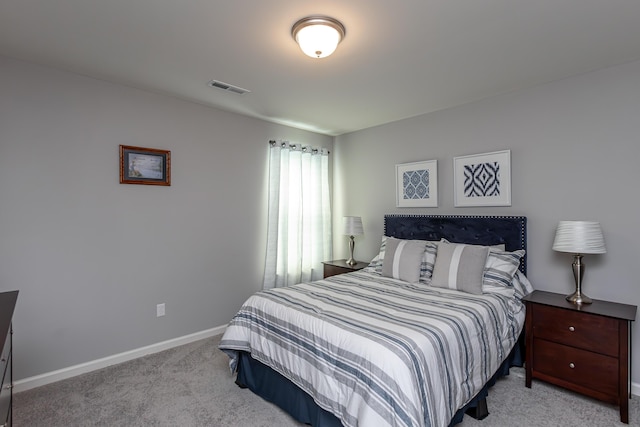 bedroom with light colored carpet, visible vents, and baseboards