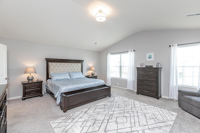 bedroom with visible vents, light colored carpet, baseboards, and vaulted ceiling