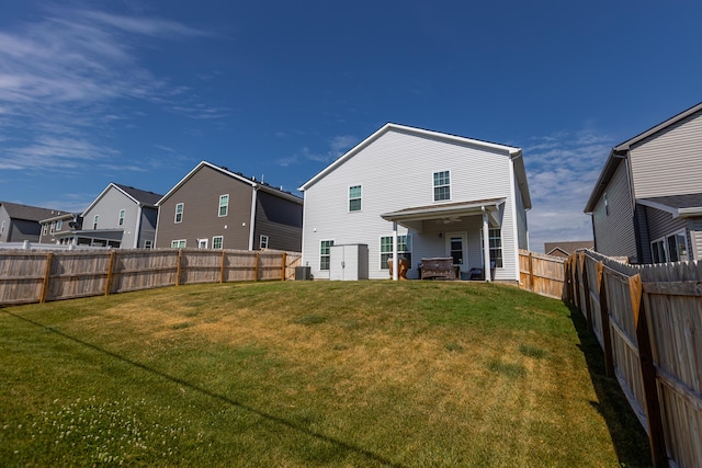 back of house featuring a lawn, a residential view, and a fenced backyard