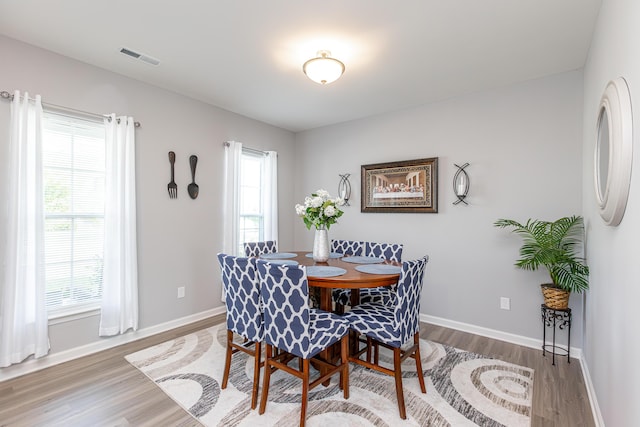 dining room featuring visible vents, baseboards, and wood finished floors