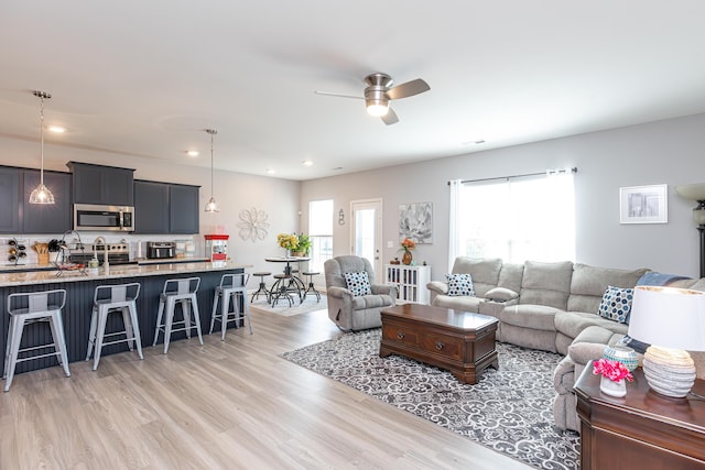 living area featuring recessed lighting, light wood-style floors, and ceiling fan