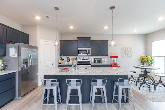 kitchen with a breakfast bar, light wood-type flooring, tasteful backsplash, and stainless steel appliances