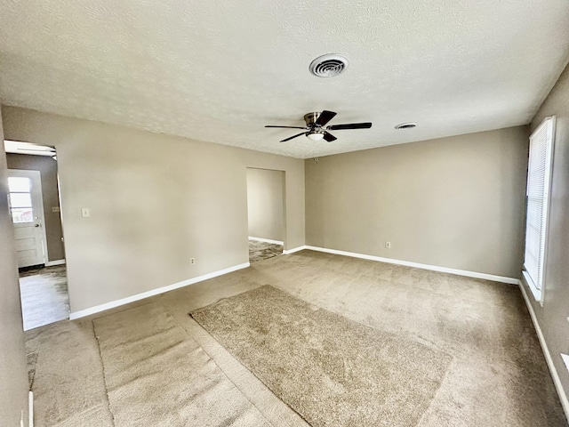 unfurnished room featuring visible vents, baseboards, a textured ceiling, and a ceiling fan