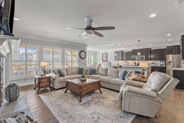 living room with recessed lighting, wood finished floors, and ornamental molding