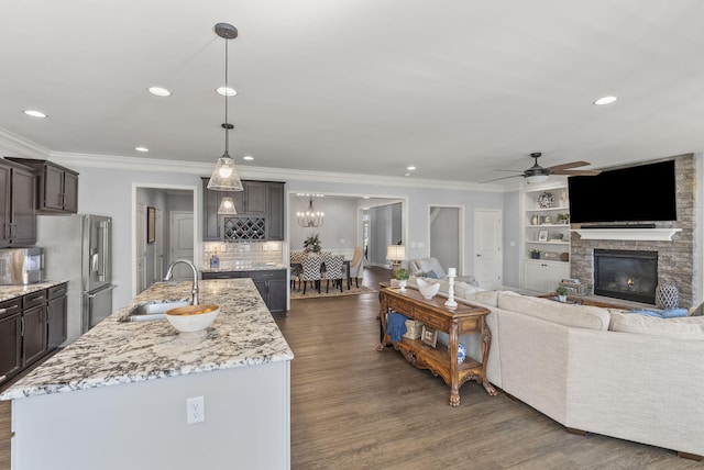 kitchen with dark wood finished floors, dark brown cabinetry, stainless steel refrigerator with ice dispenser, and a sink