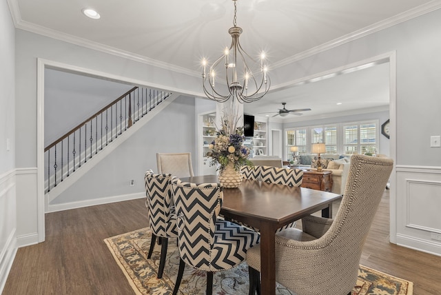 dining area featuring crown molding, dark wood-type flooring, stairway, a wainscoted wall, and a decorative wall