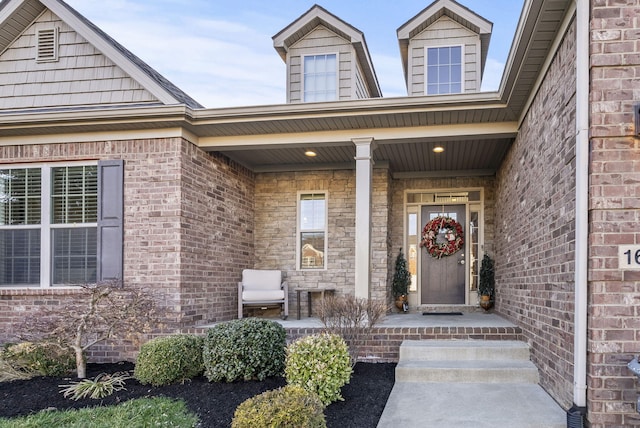 property entrance with brick siding and covered porch