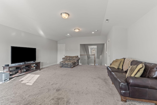 carpeted living room featuring visible vents, baseboards, and vaulted ceiling