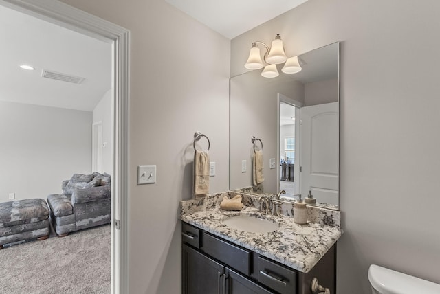 bathroom featuring visible vents, toilet, and vanity