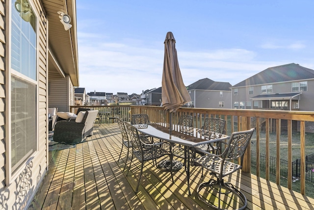 wooden deck featuring outdoor dining space and a residential view