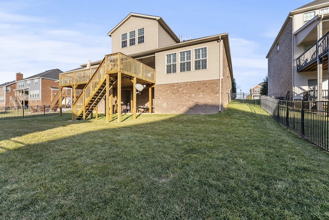 back of house featuring stairway, brick siding, a fenced backyard, and a lawn