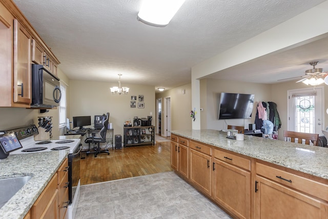 kitchen featuring light stone countertops, brown cabinets, black microwave, and electric stove