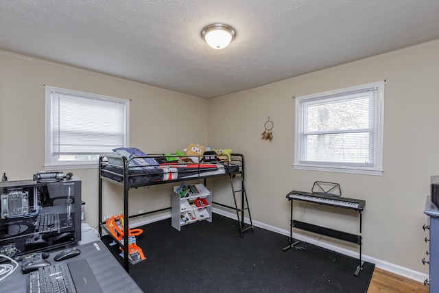 bedroom with baseboards, multiple windows, and a textured ceiling