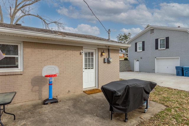 view of side of home with brick siding, an attached garage, and concrete driveway