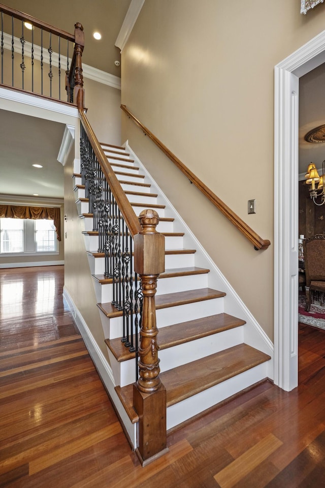 staircase featuring recessed lighting, wood finished floors, baseboards, and ornamental molding