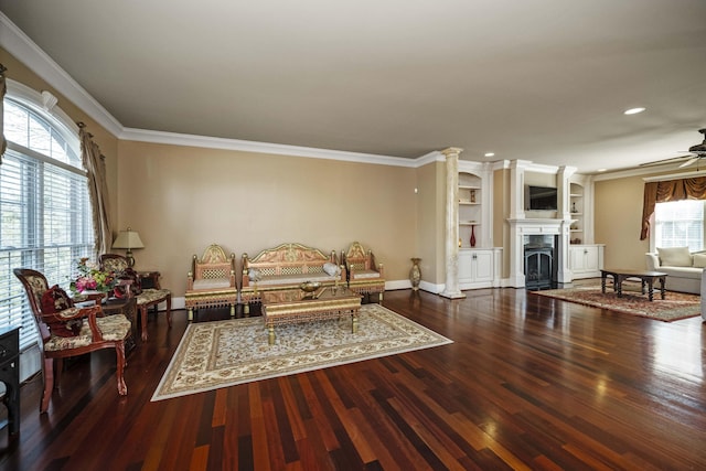 living room featuring ceiling fan, wood finished floors, ornamental molding, and a fireplace