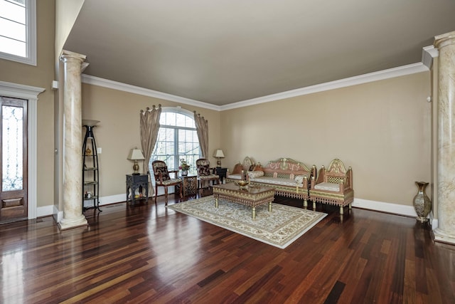 living area featuring wood finished floors, crown molding, and decorative columns