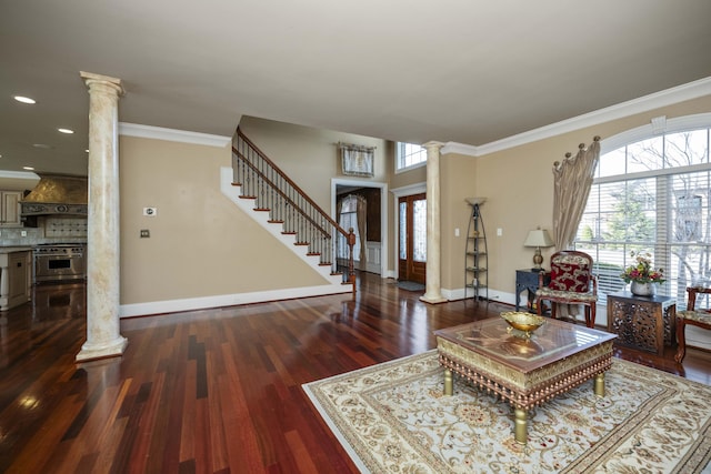 living area featuring plenty of natural light, stairs, and ornate columns