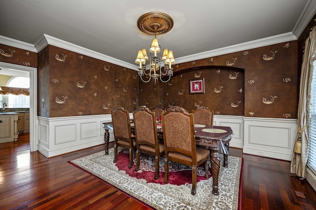 dining room with a wainscoted wall, a notable chandelier, and wood finished floors