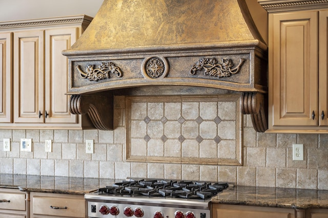 kitchen with gas stove, decorative backsplash, and dark stone countertops