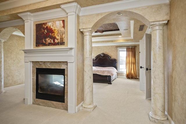 carpeted bedroom featuring arched walkways, a high end fireplace, ornate columns, and ornamental molding