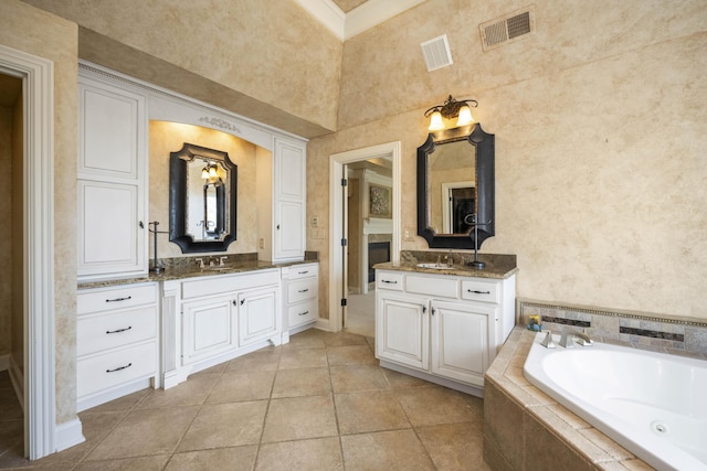 bathroom featuring visible vents, two vanities, and a sink