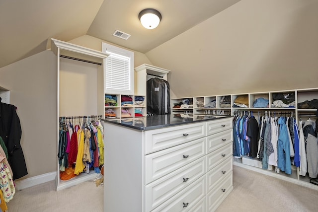 spacious closet with vaulted ceiling, visible vents, and light carpet