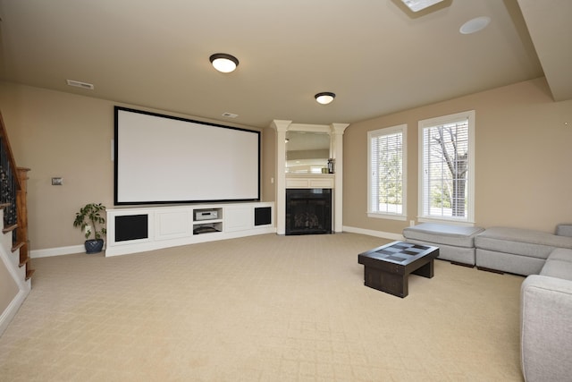 carpeted home theater with visible vents, baseboards, and a fireplace