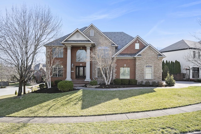 neoclassical home with a front lawn, brick siding, and stone siding