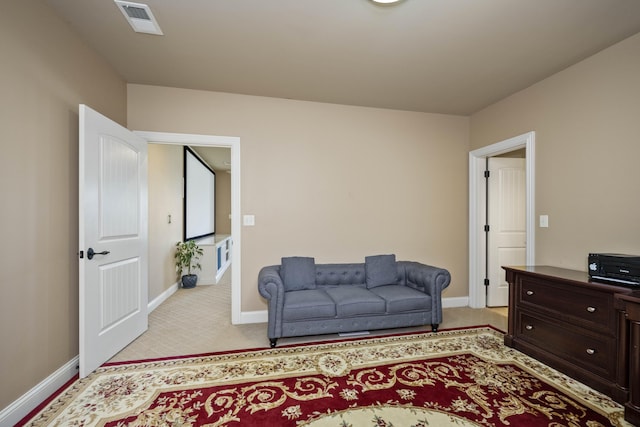 sitting room featuring light colored carpet, visible vents, and baseboards