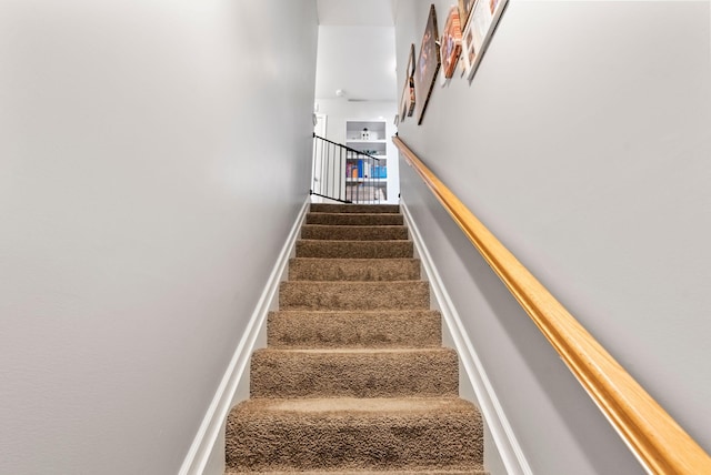 stairs featuring carpet flooring and baseboards