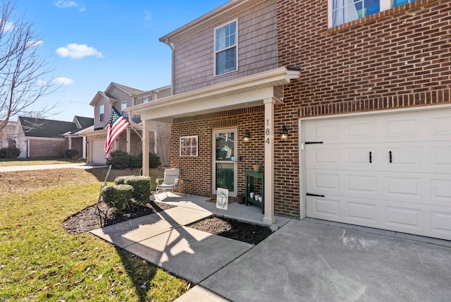 property entrance with brick siding, a lawn, driveway, and a garage