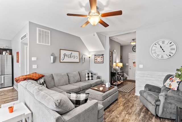 living area with vaulted ceiling, wood finished floors, visible vents, and ceiling fan