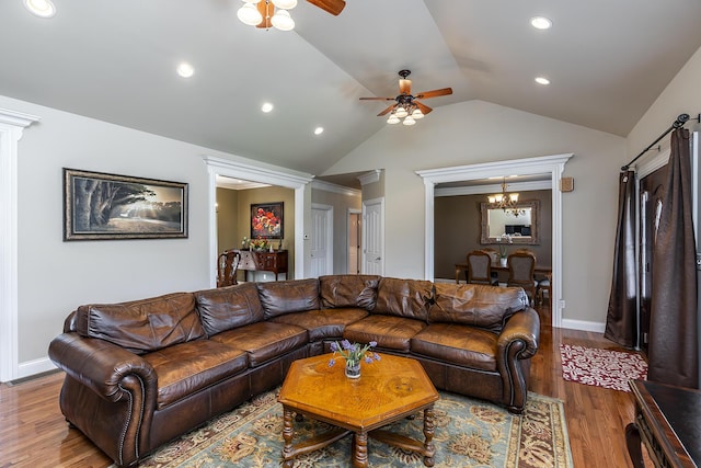 living area with recessed lighting, lofted ceiling, wood finished floors, baseboards, and ceiling fan with notable chandelier
