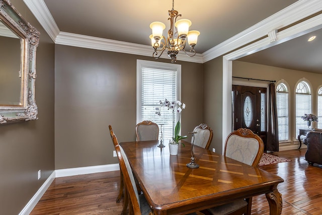 dining room featuring baseboards, wood finished floors, an inviting chandelier, and crown molding