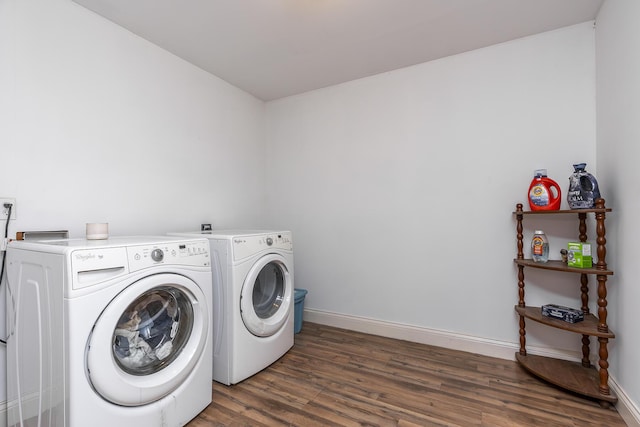 laundry area with washing machine and dryer, wood finished floors, baseboards, and laundry area