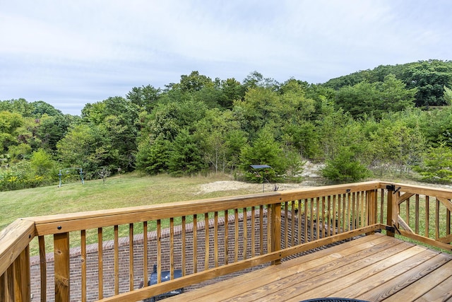 deck featuring a lawn and a forest view
