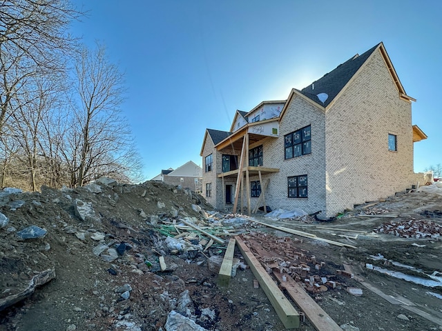 back of property with a balcony and brick siding