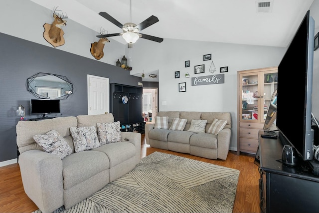 living area featuring light wood finished floors, visible vents, baseboards, high vaulted ceiling, and a ceiling fan