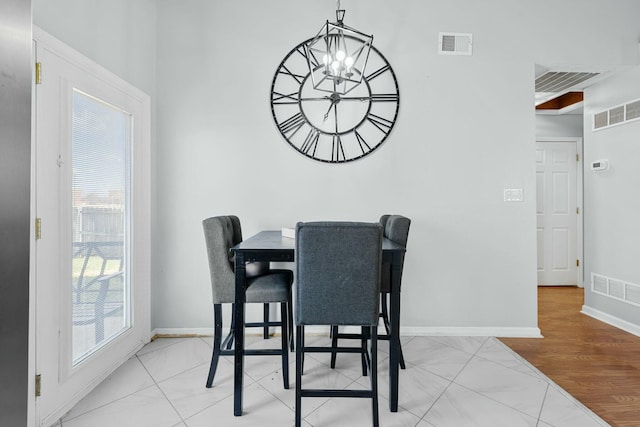 dining room with an inviting chandelier, baseboards, visible vents, and a wealth of natural light