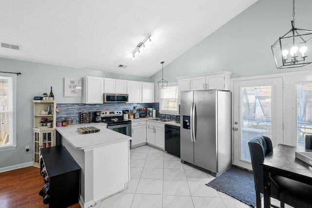 kitchen with visible vents, light countertops, appliances with stainless steel finishes, a peninsula, and white cabinetry