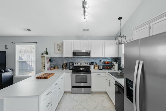 kitchen with visible vents, light countertops, appliances with stainless steel finishes, a peninsula, and a sink