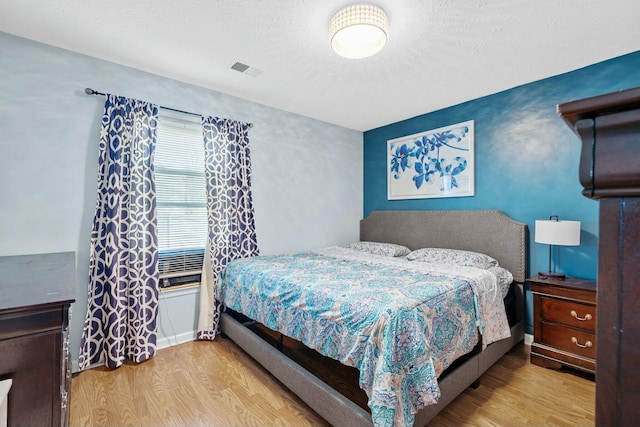 bedroom with wood finished floors and visible vents